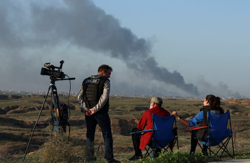  Journalists observe as smoke rises over Gaza, amid the ongoing conflict between Israel and the Palestinian Islamist group Hamas, as seen from southern Israel, December 26, 2023.  (photo credit: REUTERS/VIOLETA SANTOS MOURA)