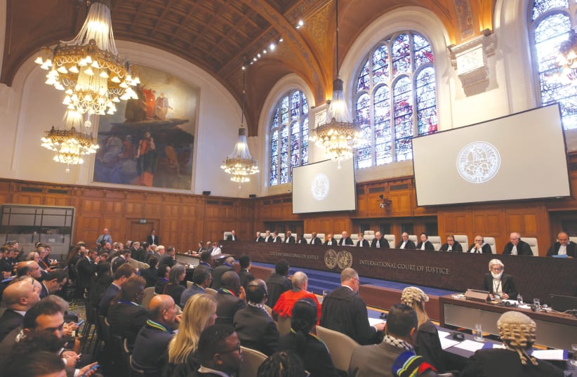  PEOPLE LISTEN to the proceedings inside the ICJ, in The Hague. (photo credit: THILO SCHMUELGEN/REUTERS)
