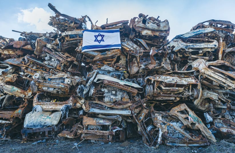  CARS DESTROYED by Hamas during the October 7 massacre are piled high in a field near the Israel-Gaza border. (photo credit: Chaim Goldberg/Flash90)
