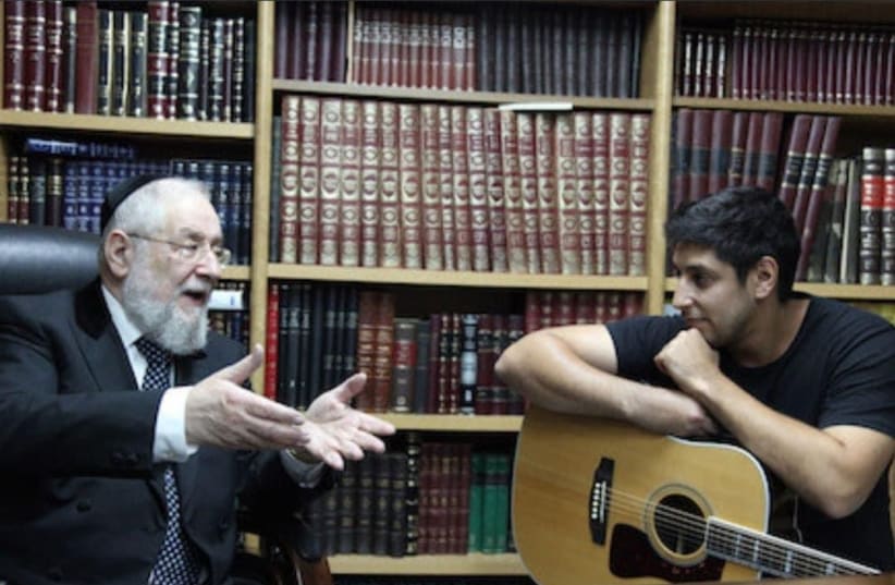  Israeli singer Idan Amedi (R), who was wounded fighting in Gaza, is seen speaking with Rabbi Yisrael Meir Lau. (photo credit: sivanrahavmeir.com)