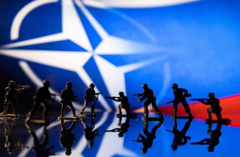  Army soldier figurines are displayed in front of the NATO logo and Russian flag colours background in this illustration taken, February 13, 2022. (photo credit: REUTERS/DADO RUVIC/ILLUSTRATION)