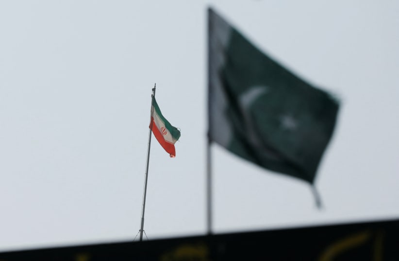 The flag of Iran is seen over its consulate building, with Pakistan's flag in the foreground, January 18, 2024. (photo credit: REUTERS/AKHTAR SOOMRO)