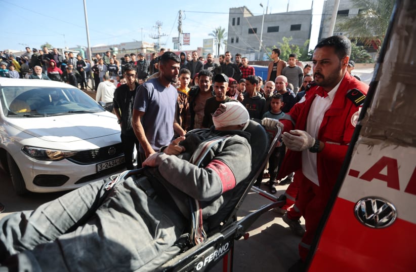  A wounded Palestinian lies as he is rushed into Nasser hospital, Khan Younis, Gaza, December 4, 2023 (photo credit: IBRAHEEM ABU MUSTAFA/REUTERS)