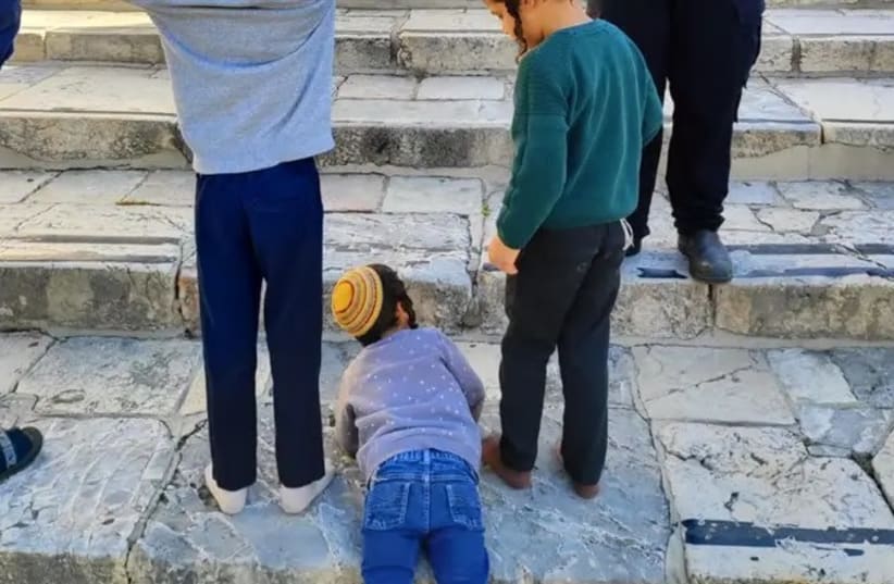 Rabbi Avraham Yitzchak Peirman's youngest son lying on the stairs at the Temple Mount.  (photo credit: Beyadenu)