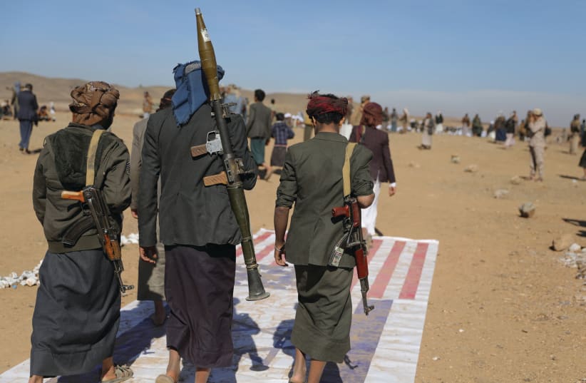  TRIBESMEN LOYAL to the Houthis trample on US and Israeli flags at the site of a parade for new tribal recruits, in Bani Hushaish, Yemen, this week (photo credit: KHALED ABDULLAH/REUTERS)