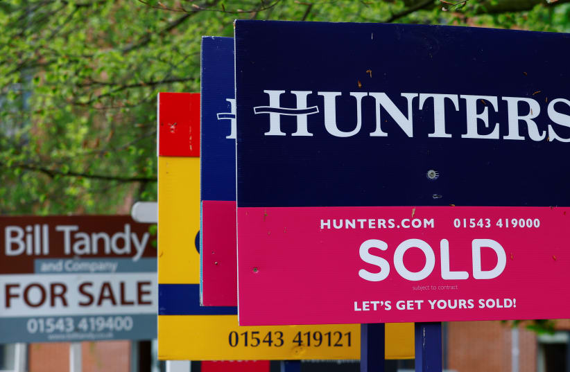  Property estate agent sales and letting signs are seen outside an apartment building in Lichfield, Britain, May 3, 2022.  (photo credit:  REUTERS/Andrew Boyers)