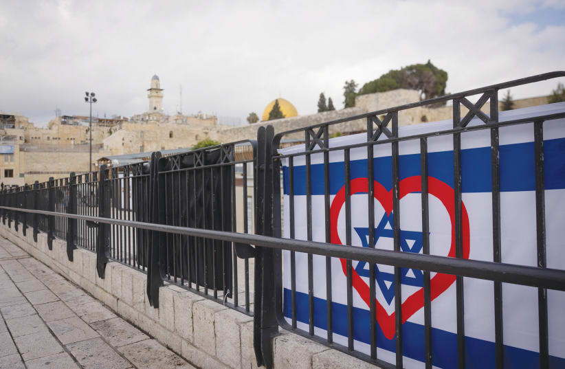  AN ISRAELI flag is enhanced with a heart in Jerusalem’s Old City. As we’ve seen firsthand over the past three and a half months, we are so much more powerful when, despite our differences, we are united under one banner, the writer affirms.  (photo credit: FLASH90/CHAIM GOLDBERG)