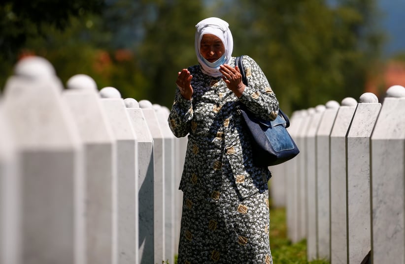  A woman prays next to the graves at Potocari-Srebrenica Memorial, in Potocari, near Srebrenica, Bosnia And Herzegovina July 10, 2020 (photo credit: REUTERS/DADO RUVIC)