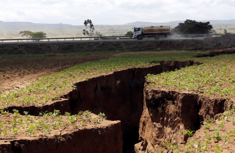  Un camión cisterna circula cerca de una sima que se sospecha ha sido causada por un fuerte aguacero a lo largo de una falla subterránea cerca de la ciudad de Mai-Mahiu, en el Valle del Rift. (photo credit: REUTERS)
