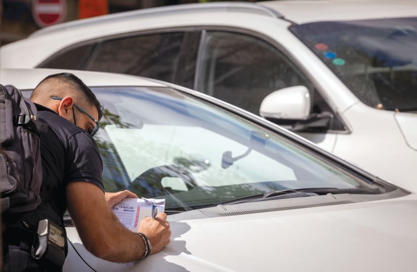 A Jerusalem municipal inspector writes out a parking ticket. (photo credit: NATI SHOHAT/FLASH90)