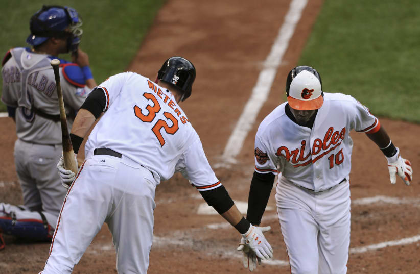  Baltimore Orioles batter Adam Jones (10) celebrates with Baltimore Orioles Matt Wieters in the seventh inning against the Texas Rangers in their first game of a doubleheader during their MLB American League baseball game in Baltimore, Maryland, May 10, 2012. (photo credit: REUTERS/Patrick Smith)
