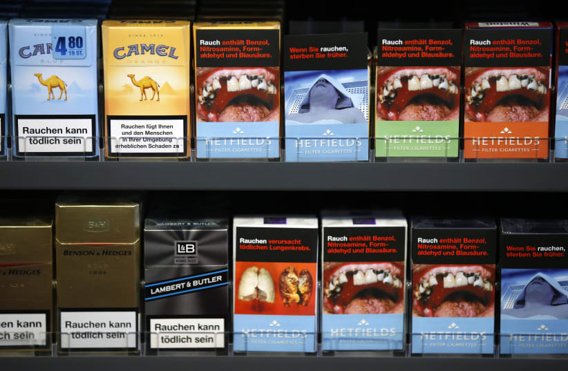 Cigarette boxes with an affixed, self-made cigarette label displaying graphic images (R) and those with the original label are pictured in the shop of tobacconist and kiosk owner Janine Schulzki in Berlin  (photo credit: REUTERS/FABRIZIO BENSCH)