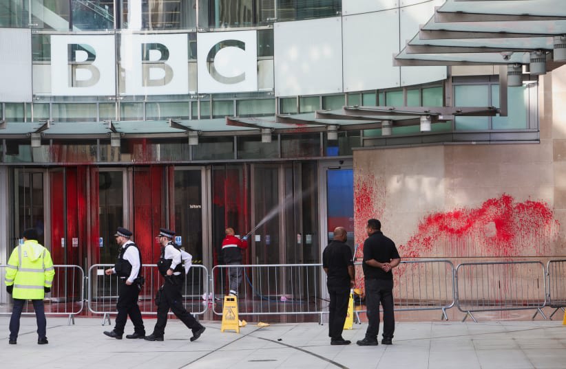 Oficiales de policía caminan fuera del edificio de la BBC, cerca del inicio de una marcha pro-palestina cubierta de pintura roja, en medio del conflicto Israel-Hamas, en Londres, el 14 de octubre de 2023. (photo credit: REUTERS/Susannah Ireland)