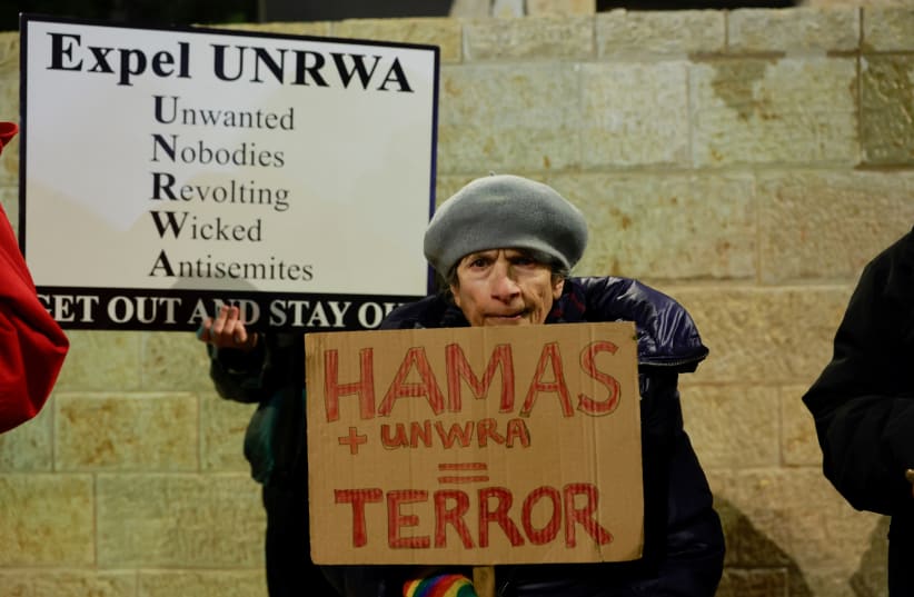  Israeli protesters hold placards as they demonstrate outside the UNRWA offices, amid the ongoing conflict between Israel and Hamas, in Jerusalem February 5, 2024 (photo credit: AMMAR AWAD/REUTERS)