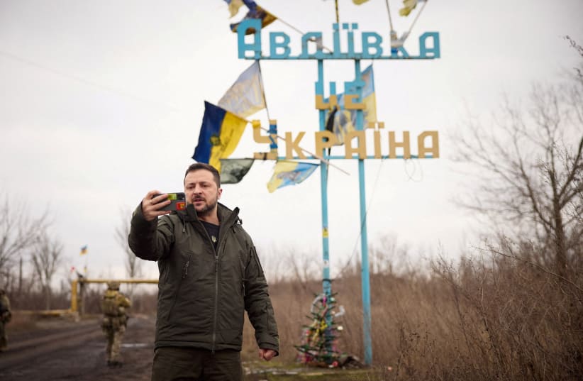  Ukraine's President Volodymyr Zelenskiy takes a video in front of a road sign with the words "Avdiivka this is Ukraine", amid Russia's attack on Ukraine, December 29, 2023. (photo credit: Ukrainian Presidential Press Service/Handout via REUTERS)