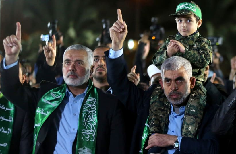  El hijo del importante terrorista de Hamás, Mazen Fuqaha, se sienta sobre los hombros del jefe de Hamás en Gaza, Yahya Sinwar. (photo credit: REUTERS)