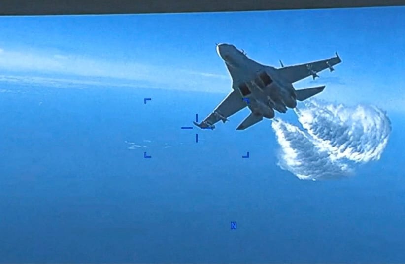  Un avión militar ruso Su-27 vierte combustible mientras vuela junto a un dron MQ-9 "Reaper" de la Fuerza Aérea estadounidense sobre el Mar Negro, el 14 de marzo de 2023 en esta imagen fija tomada de un vídeo de distribución difundido por el Pentágono. (photo credit: Courtesy of US European Command/The Pentagon/Handout via REUTERS)