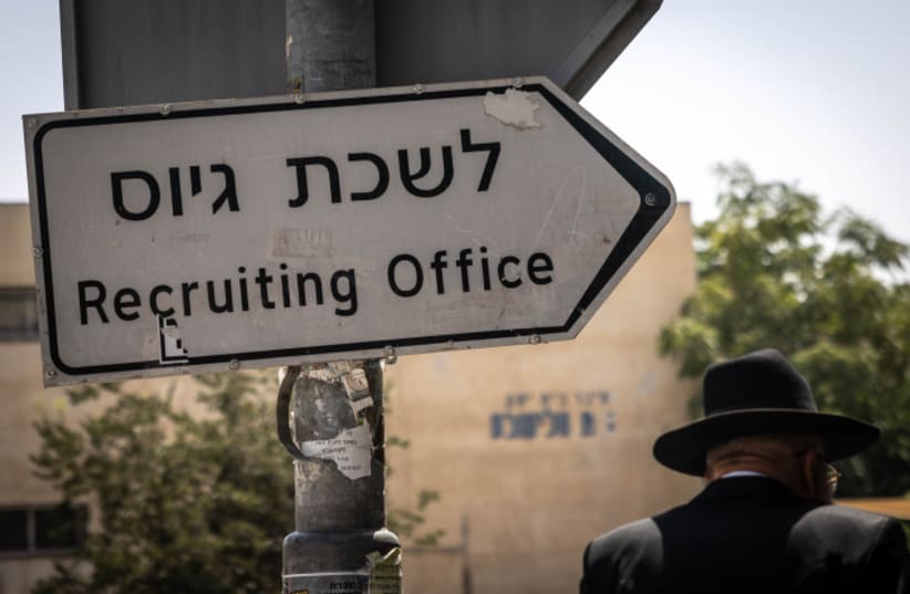  Ultra-Orthodox Jews walk outside the army recrutiment office in Jerusalem, August 16, 2023 (photo credit: Chaim Goldberg/Flash90)
