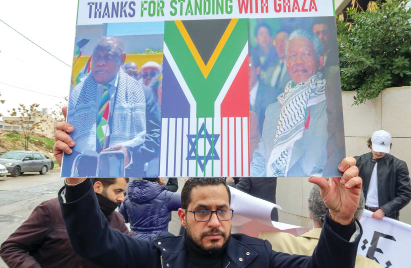  A Palestinian demonstrator holds a sign thanking South Africa for its support during a protest in Amman, Jordan. (photo credit: JEHAD SHELBAK/REUTERS)