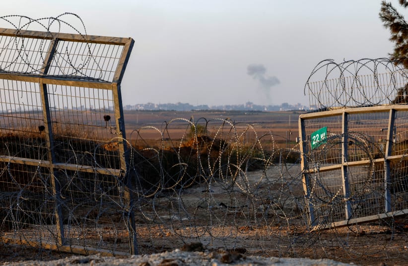 Дым поднимается над сломанным забором в Кфар-Азе, куда вошли террористы ХАМАС во время нападения 7 октября, на юге Израиля, 5 ноября 2023 г. (фото: ЭВЕЛИН ХОКШТЕЙН/REUTERS)