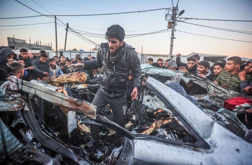  Palestinos en el lugar de un coche de policía destruido tras ser alcanzado por un ataque aéreo israelí en Rafah, el 7 de febrero de 2024. (photo credit: ATIA MOHAMMED/FLASH90)