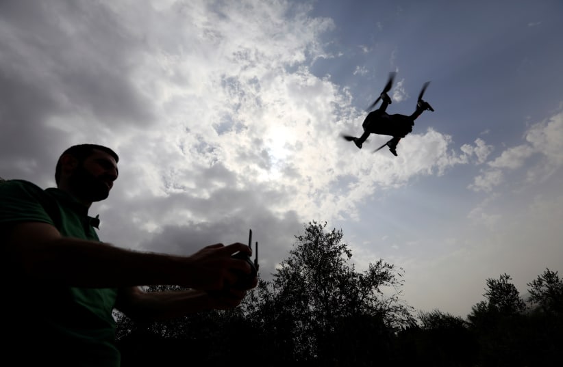  A man operates a drone over olive trees in Nabatieh area, Lebanon October 25, 2018 (photo credit: REUTERS/JAMAL SAIDI)