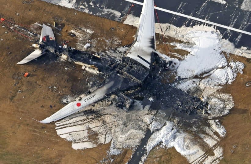  Una vista aérea muestra quemado el avión Airbus A350 de Japan Airlines (JAL) después de una colisión con un avión de la Guardia Costera de Japón en el Aeropuerto Internacional de Haneda en Tokio, Japón 3 de enero 2024, en esta foto tomada por Kyodo. (photo credit: KYODO/VIA REUTERS)