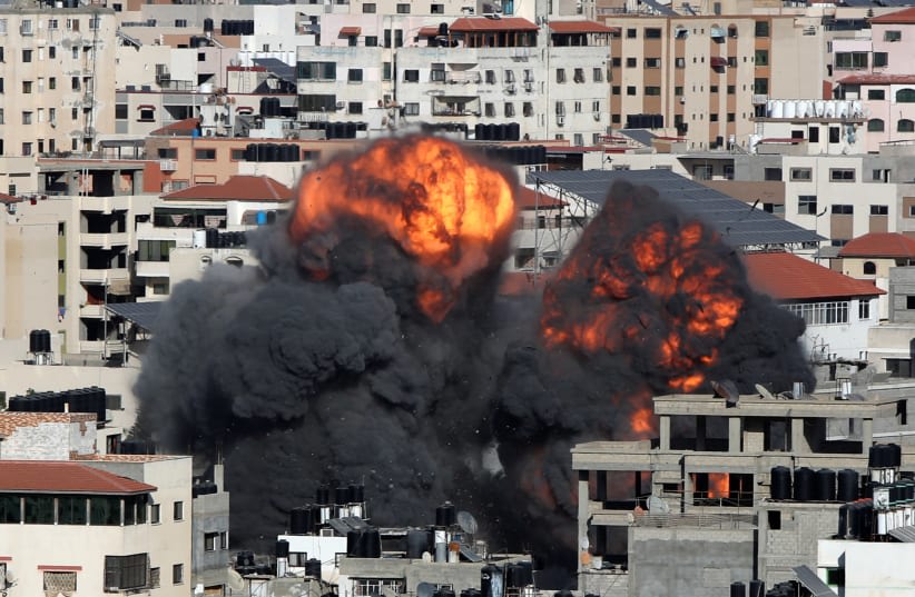  El humo y las llamas se elevan durante un ataque aéreo israelí, en medio de un recrudecimiento de la violencia israelo-palestina, en la ciudad de Gaza 14 de mayo 2021. (photo credit: MOHAMMED SALEM/ REUTERS)