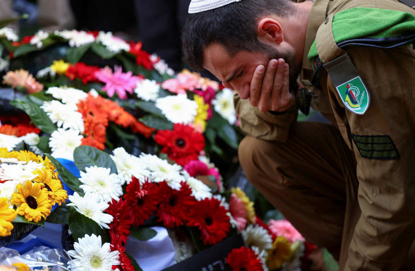  A soldier reacts as friends and family mourn Israeli soldier Staff Sergeant Aschalwu Sama who died of wounds sustained in November during the ground invasion by Israel's military in the northern Gaza Strip, at his funeral in Petah Tikva (photo credit: ATHIT PERAWONGMETHA / REUTERS)