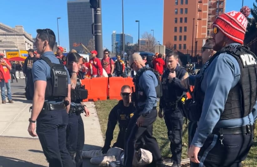 Police officers detain a person outside of Union Station following a shooting near an outdoor celebration of the NFL champion Chiefs' Super Bowl victory, in Kansas City, Missouri, U.S. February 14, 2024 in this screen grab obtained from social media video. (photo credit: Alyssa Contreras/via REUTERS)