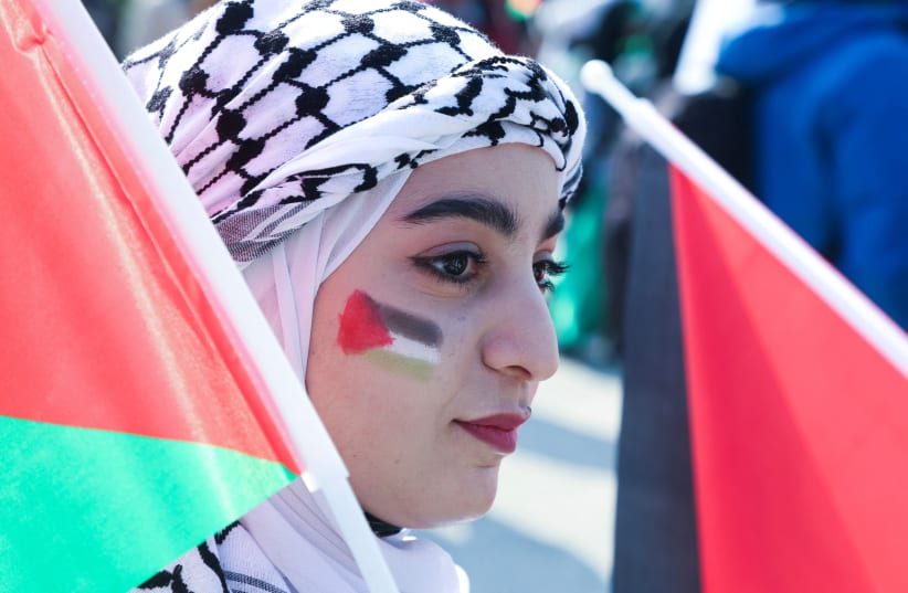  A woman with the colours of the Palestinian flag painted on her face attends a protest in support of Palestinians in Gaza, in Beirut, Lebanon February 11, 2024 (photo credit: MOHAMED AZAKIR/REUTERS)