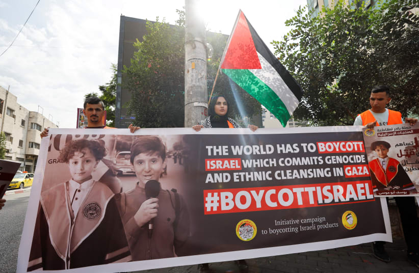  Los palestinos llaman al boicot de productos israelíes durante una protesta en apoyo al pueblo de Gaza, mientras continúa el conflicto entre Israel y el grupo islamista palestino Hamás, en Hebrón, en la Cisjordania ocupada por Israel, el 28 de octubre de 2023. (photo credit: REUTERS/MUSSA QAWASMA)