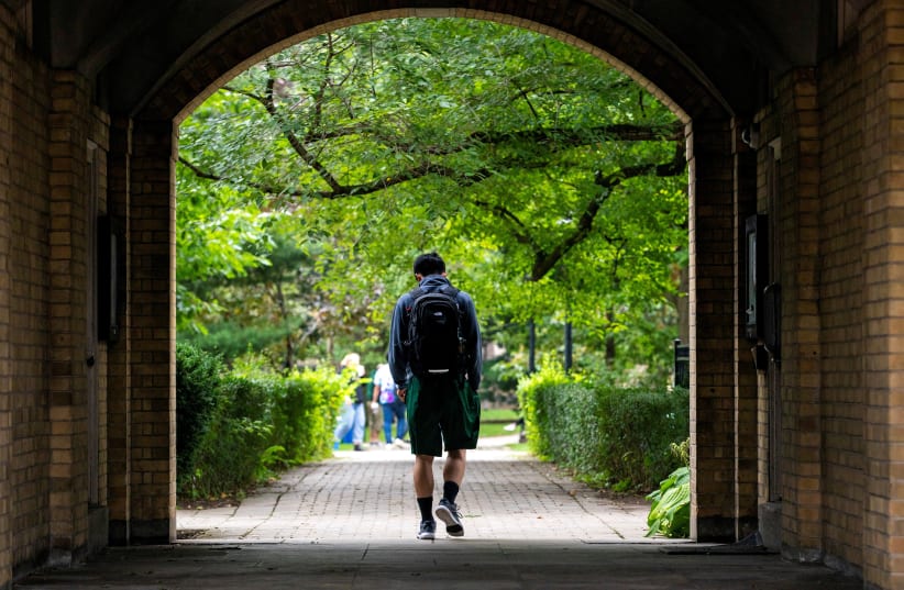  People walk on the grounds of the University of Toronto in Toronto, Ontario (photo credit: CARLOS OSORIO/REUTERS)