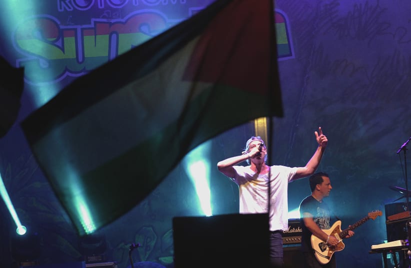  A Palestinian flag flies as U.S. Jewish musician Matisyahu performs on stage during the Rototom Sunsplash festival in Benicassim, August 23, 2015. The Spanish reggae festival, bowing to an international outcry, on Wednesday reversed its decision to cancel an invitation to Matisyahu because he had f (photo credit: HEINO KALIS / REUTERS)