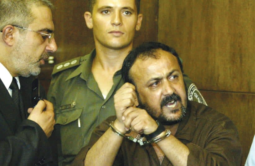  MARWAN BARGHOUTI se dirige a los medios de comunicación en el Tribunal de Distrito de Tel Aviv, en 2002, gritando en hebreo: "La Intifada vencerá". Condenado por asesinato en masa, Barghouti lleva encarcelado desde 2002, señala el escritor. (photo credit: REUTERS)