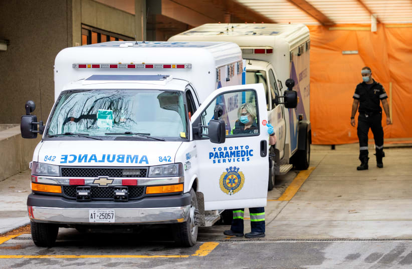  Paramedics enter their ambulance parked at Mount Sinai Hospital as the city enters the first day of a renewed coronavirus disease (COVID-19) lockdown due to a spike in cases in Toronto, Ontario, Canada November 23, 2020. (photo credit: REUTERS/CARLOS OSORIO)