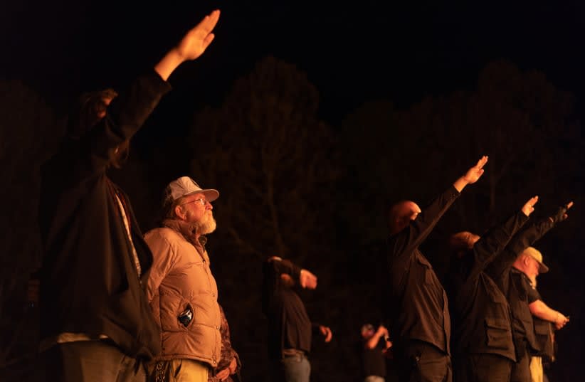  Simpatizantes del Movimiento Nacional Socialista, un grupo político nacionalista blanco, hacen saludos nazis mientras participan en una quema de esvásticas en un lugar no revelado en Georgia, Estados Unidos, el 21 de abril de 2018. (photo credit: REUTERS)