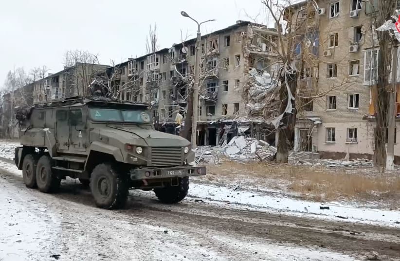  A Russian military vehicle drives past residential buildings damaged in the course of Russia-Ukraine conflict in the town of Avdiivka in the Donetsk Region, Russian-controlled Ukraine, in this image taken from video released February 20, 2024 (photo credit: RUSSIAN DEFENSE MINISTRY/HANDOUT VIA REUTERS)