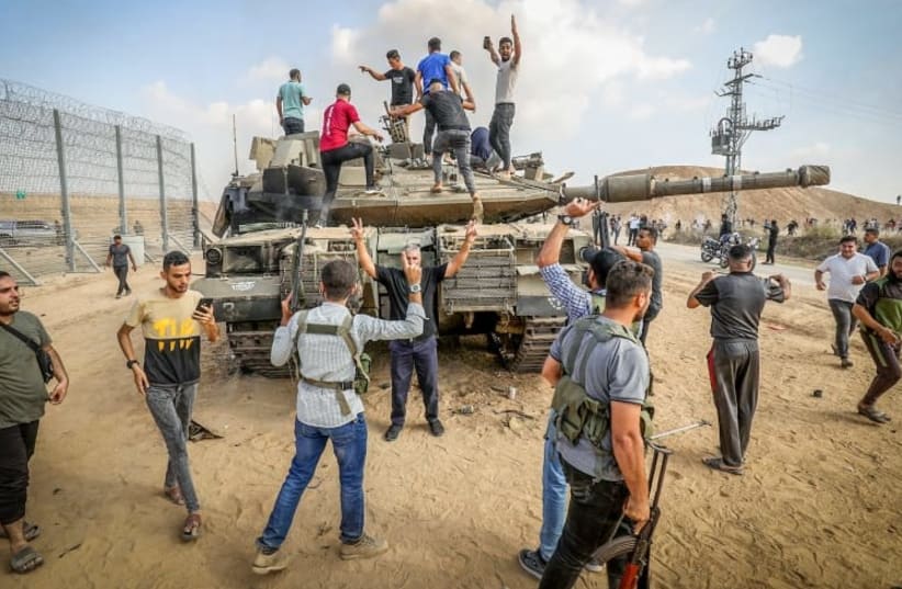  Palestinos se hacen con el control de un tanque israelí tras cruzar la valla fronteriza con Israel desde Jan Yunis, en el sur de la Franja de Gaza, el 7 de octubre de 2023. (photo credit: ABED RAHIM KHATIB/FLASH90)