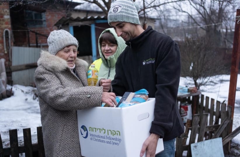  VALENTINA, WHO lives in rural areas of the Sumy Oblast, receives an aid package from IFCJ representatives.  (photo credit: Aleksandr Rozhenyuk)