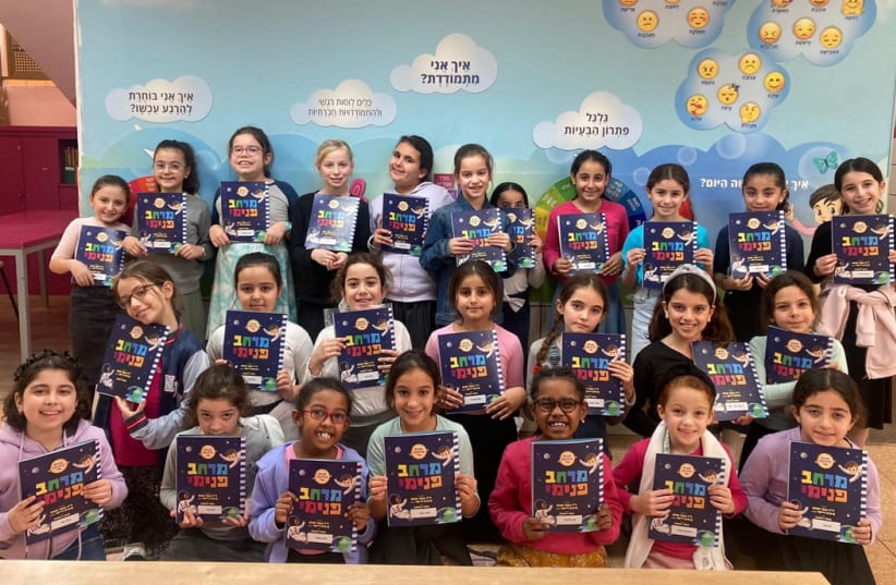  Israeli children in the city of Sderot holding a translated version of the book "Inner Space: My resilience workbook." (photo credit: COURTESY)