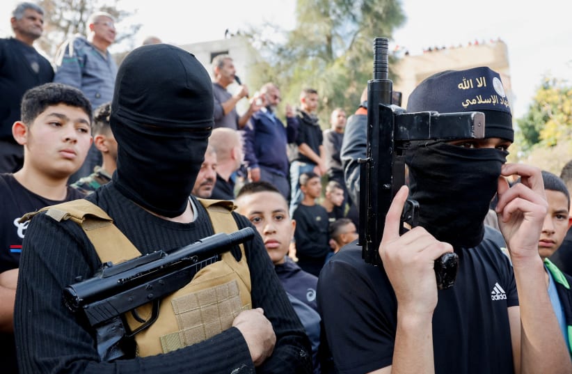 People with guns attend the funeral of Palestinians killed during an Israeli raid in Far'a camp, amid the ongoing conflict between Israel and the Palestinian terrorist group Hamas, at the camp, near Tubas in the West Bank. (photo credit: RANEEN SAWAFTA/REUTERS)