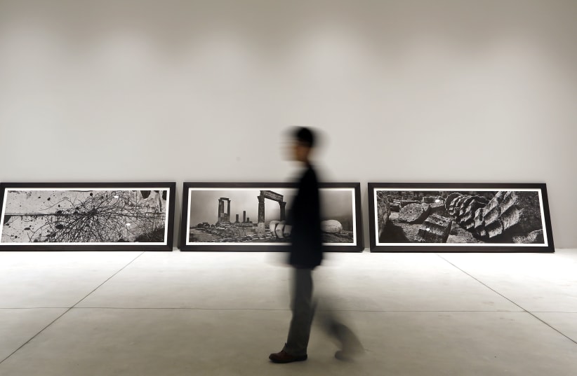  A visitor walks past pictures representing the "uncreation" theme, by famed Czech photographer Josef Koudelka, at the Holy See pavilion during the 55th La Biennale of Venice May 28, 2013. (photo credit: REUTERS/STEFANO RELLANDINI)