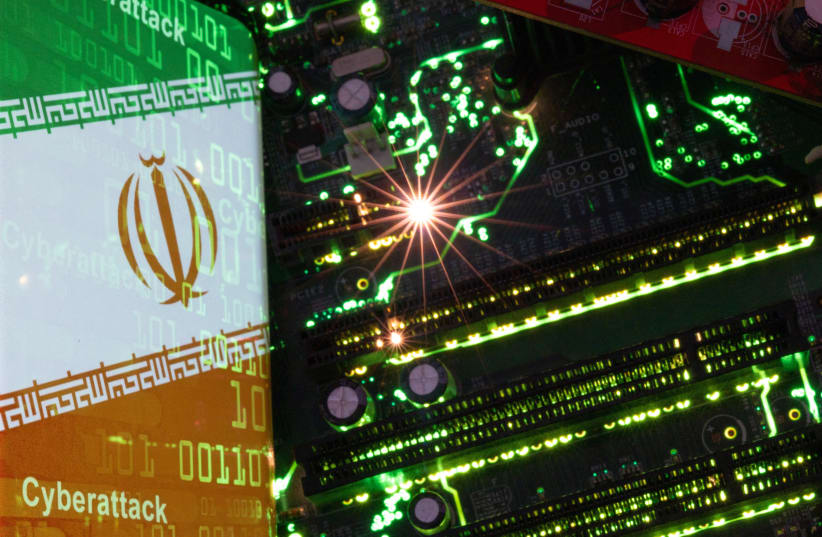  Un smartphone con una bandera iraní desplegada con la palabra "Ciberataque" y códigos binarios sobre ella se coloca sobre la placa base de un ordenador en esta ilustración tomada el 23 de febrero de 2023. (photo credit: DADO RUVIC/REUTERS)