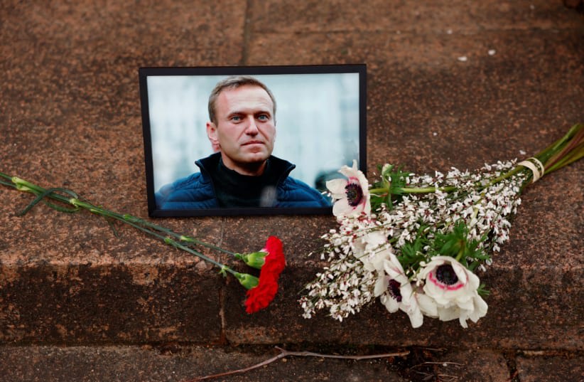  Flores y un retrato del líder opositor ruso Alexei Navalny son vistos cerca de la embajada rusa en París, Francia, 16 de febrero de 2024. (photo credit: REUTERS/GONZALO FUENTES)