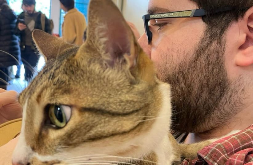  The writer, Aaron Reich, is seen with their cat, Medici (full name HaRav Medici di Cuddlebutt Reich) waiting to vote in Jerusalem for the municipal elections, on February 27, 2024. (photo credit: Courtesy)
