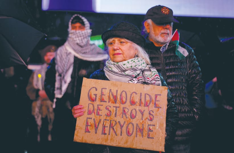  A WOMAN holds a placard accusing Israel of committing genocide as she attends a vigil for US Airman Aaron Bushnell in New York, this week. (photo credit: Reuters/Adam Gray)