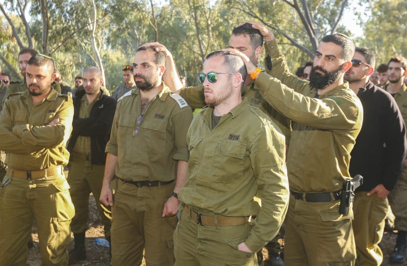  IDF SOLDIERS visit the site of the Supernova music festival massacre in Re’im, near the Israel-Gaza border. While the Israeli people are still at war, it is too early to fully understand the effects of the Hamas attacks on the country and the people, says the writer.  (photo credit: EDI ISRAEL/FLASH90)
