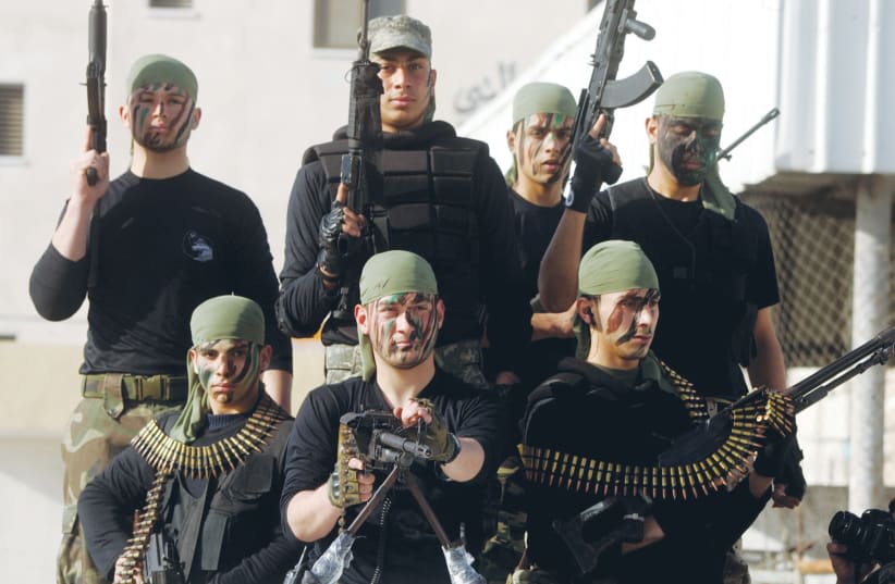  JÓVENES PALESTINOS participan en un campamento de verano de Hamás, donde reciben formación tanto militar como religiosa, en Rafah, 2014. El objetivo principal de Hamás es la destrucción de Israel como parte de una visión apocalíptica, señala el escritor. (photo credit: ABED RAHIM KHATIB/FLASH90)