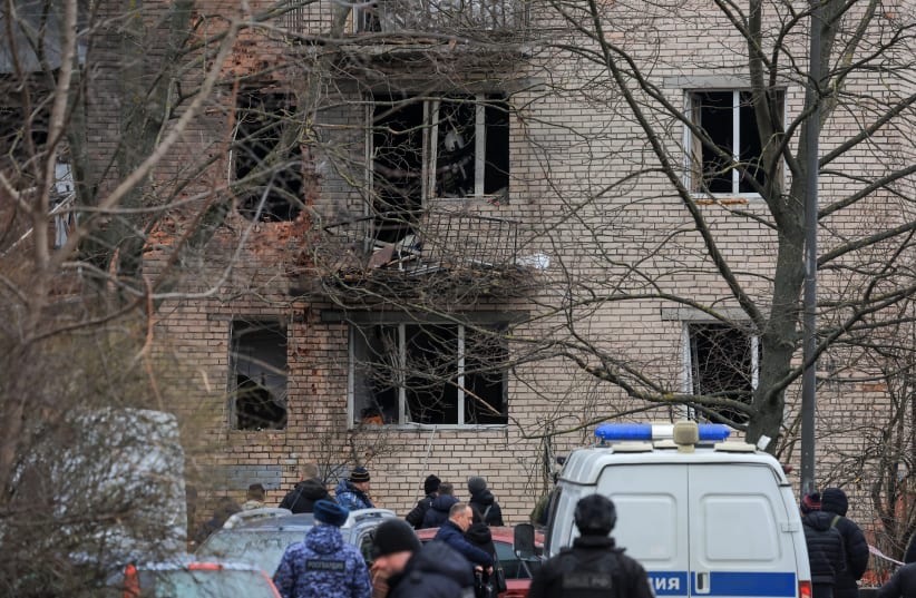  Miembros de los servicios de emergencia e investigadores se reúnen cerca de un edificio residencial de varias plantas dañado tras un presunto ataque con drones en San Petersburgo, Rusia, 2 de marzo de 2024. (photo credit: STRINGER/ REUTERS)